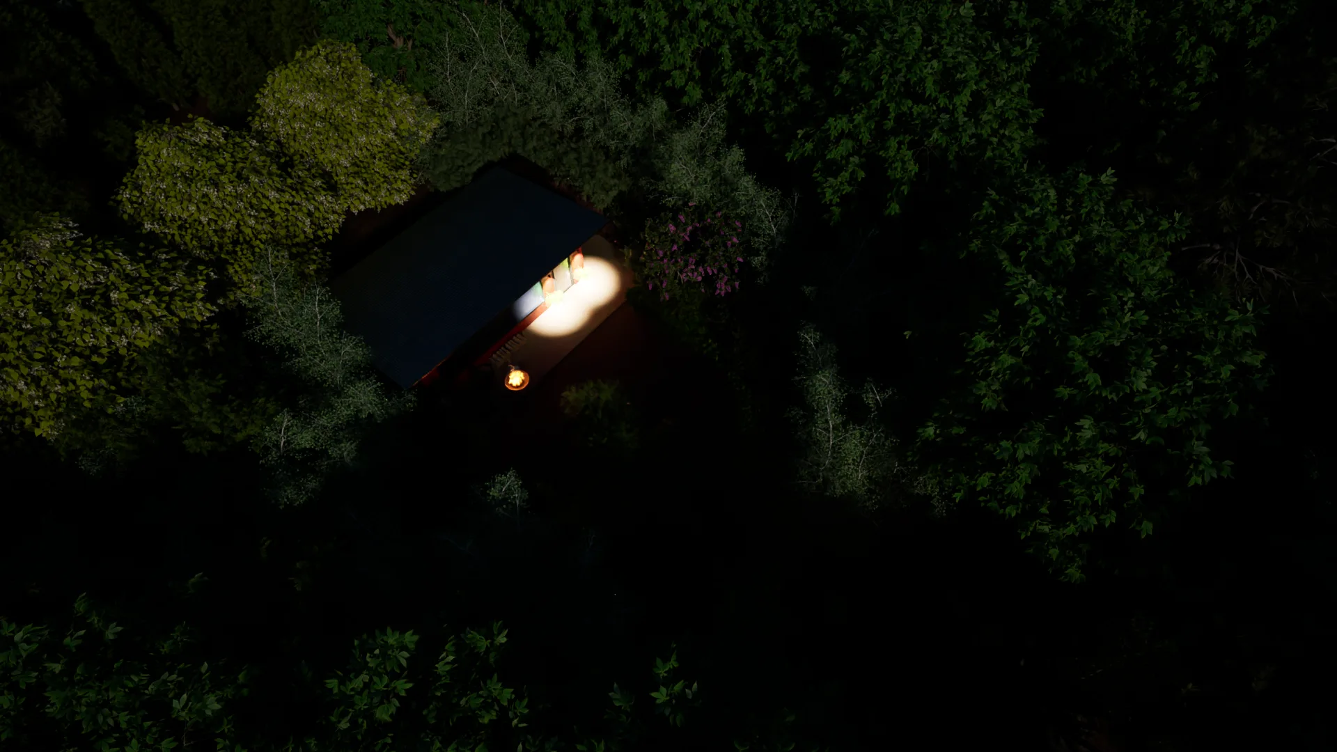 Aerial nighttime view of a cabin with patio lit